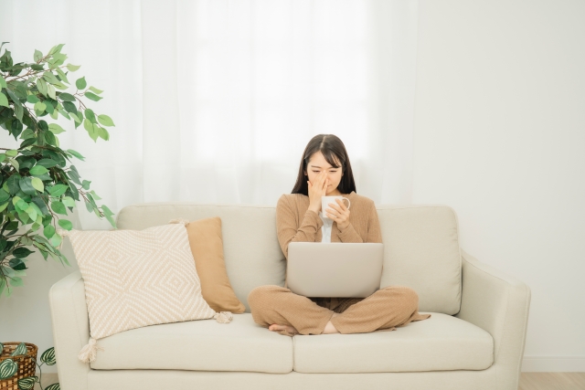 PCを見ながら涙する女性