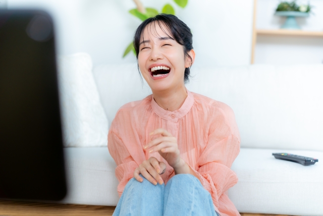 テレビを見て笑う女性